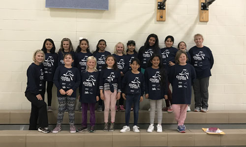 Girls posing as a group with matching tshirts 